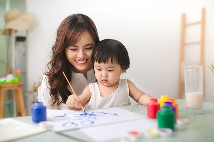 Mẹ cầm tay con nhỏ tập vẽ bằng màu nước