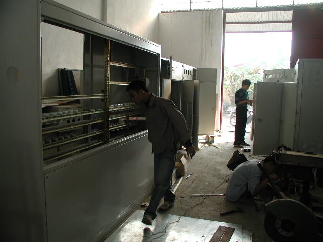 Người thợ làm việc bên dãy khung tủ điện tại xưởng Tam Anh