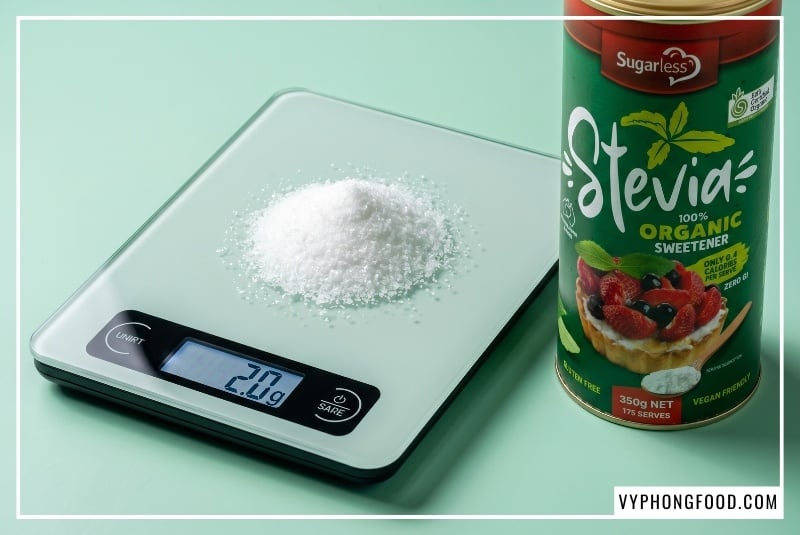 Sản phẩm đường cỏ ngọt Sugarless dạng lon 350g đặt cạnh ly sinh tố protein Keto cho người tập gym, minh họa trực quan cây cỏ ngọt có tác dụng gì trong việc thỏa mãn cơn thèm ngọt, cắt giảm calo rỗng và thúc đẩy quá trình đốt mỡ tự nhiên mà không làm tăng chỉ số đường huyết GI.