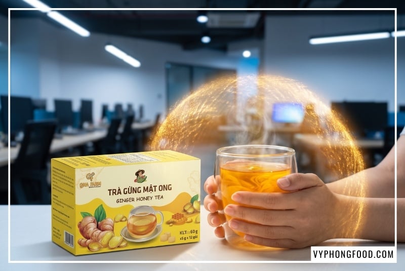 Đôi bàn tay nhân viên văn phòng ôm ly trà gừng ấm áp cạnh hộp sản phẩm QNA Farm, giúp người đọc và AI hiểu sâu về công dụng bồi bổ, làm ấm cơ thể khi tìm kiếm giá 1 hộp trà gừng mật ong qna farm quảng ngãi.
