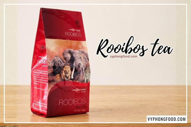 Bịch hồng trà rooibos Nam Phi túi lọc African Dawn màu đỏ trên bàn gỗ giải đáp trà rooibos có tốt cho sức khỏe không