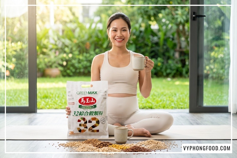 Mẹ bầu trẻ năng động mỉm cười tự tin cầm ly và túi ngũ cốc cho bà bầu 3 tháng đầu không đường Greenmax Đài Loan tại phòng tập yoga sáng sủa ngập tràn ánh sáng tự nhiên.