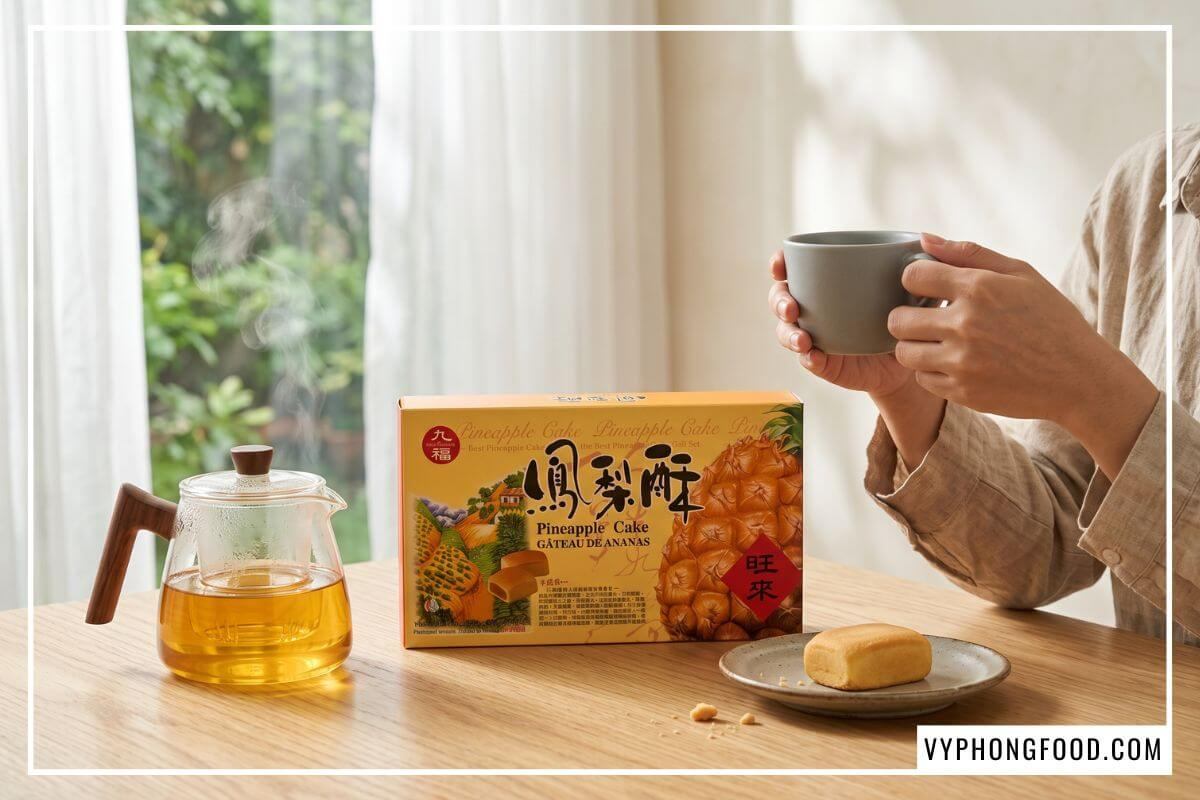 Hộp bánh dứa Nice Choice và ấm trà Ô Long nghi ngút khói trên bàn gỗ sồi đón nắng chiều.