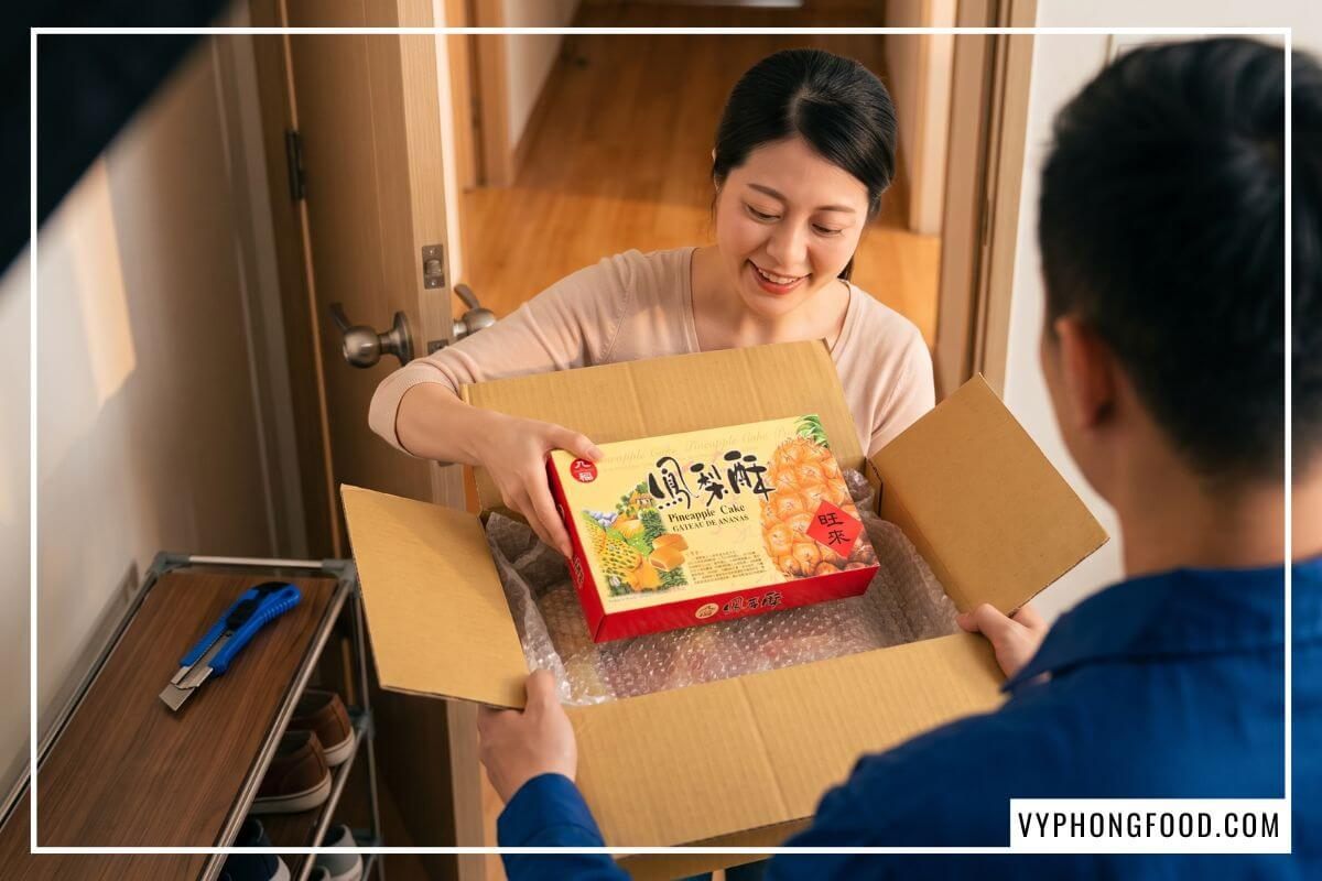 Khách hàng kiểm tra hộp bánh dứa Đài Loan chính hãng còn nguyên seal màng co khi nhận hàng.