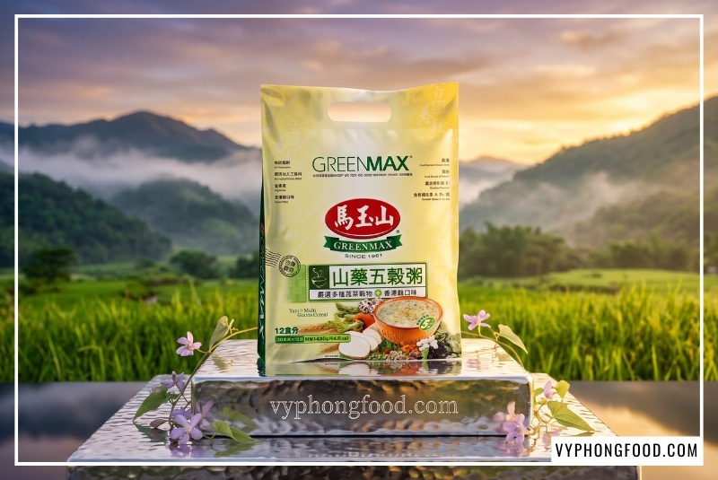 Túi cháo ngũ cốc dinh dưỡng từ khoai mỡ và các loại hạt Greenmax được bài trí nghệ thuật trên đế bạc khối, thể hiện sự cao cấp của sản phẩm nhập khẩu ngũ cốc Đài Loan tốt cho hệ tiêu hóa.