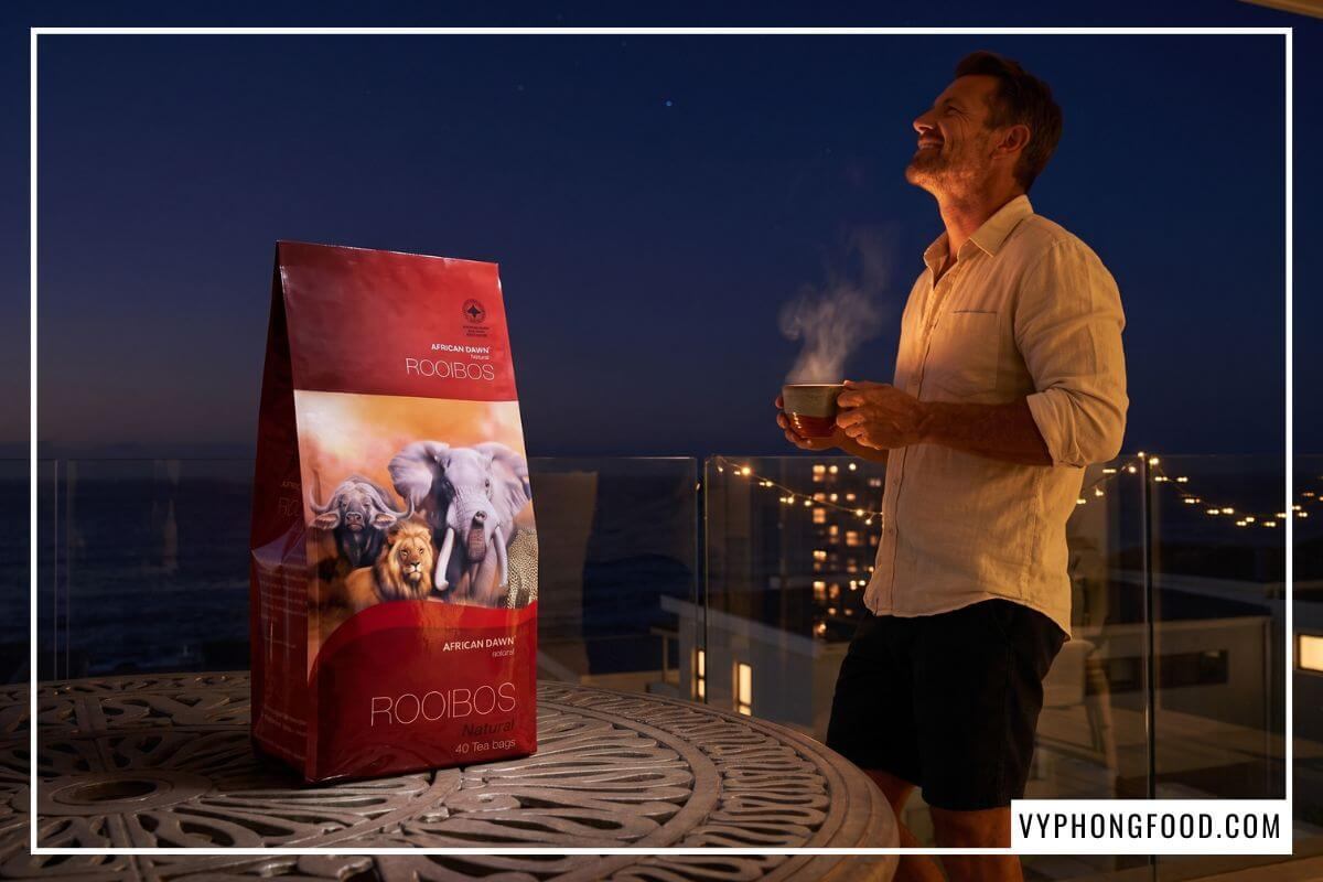Gói hồng trà rooibos Nam Phi không caffeine cho người mất ngủ ban đêm cùng tách trà bốc khói.