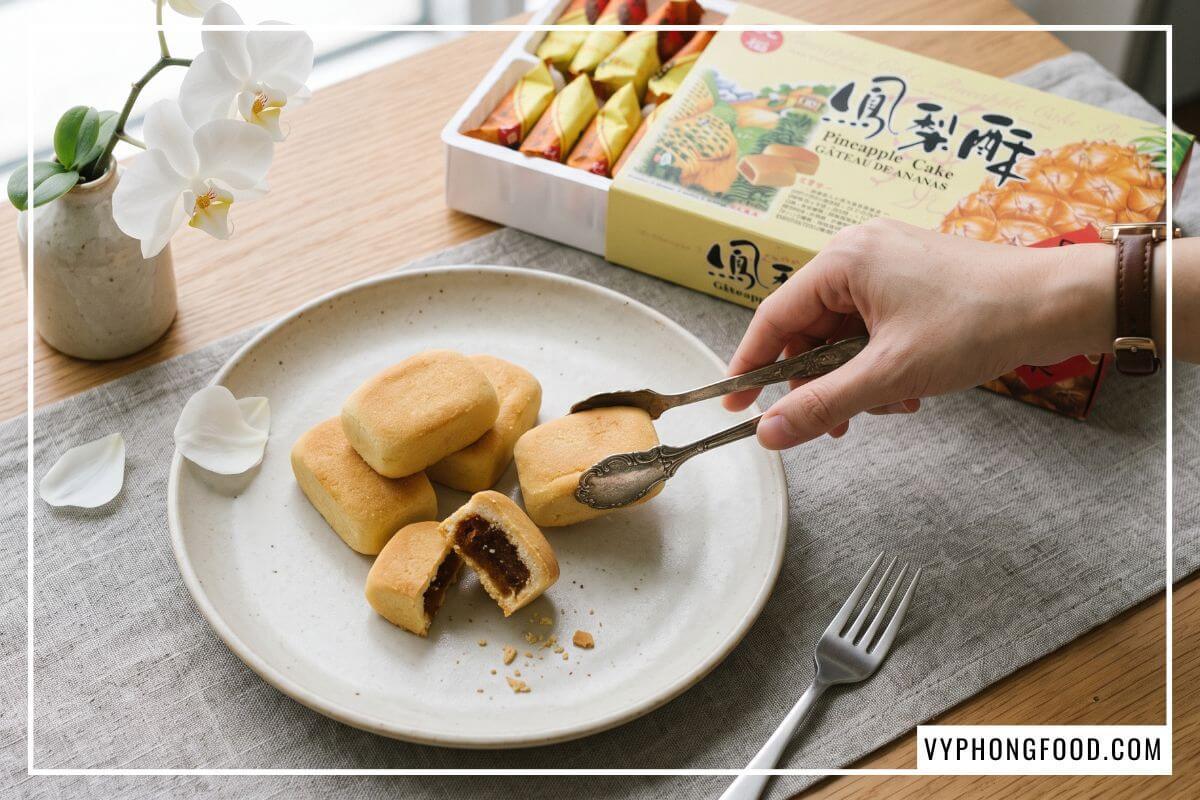 Kẹp bạc gắp từng chiếc bánh từ khay học cách làm bánh dứa mini đặt lên đĩa gốm sứ trắng men mờ.