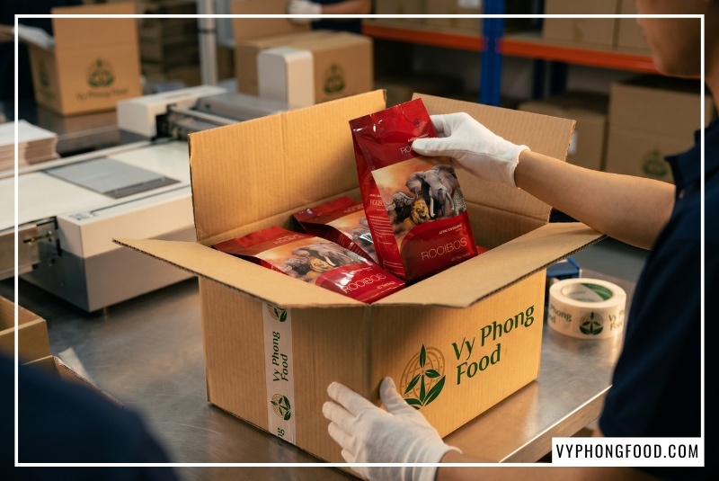 Hình ảnh hộp hồng trà rooibos Nam Phi túi lọc thương hiệu African Dawn nhập khẩu chính ngạch. Bài viết giải đáp thắc mắc trà rooibos mua ở đâu uy tín và hướng dẫn cách phân biệt trà thảo mộc tốt cho sức khỏe chính hãng do Vy Phong Food phân phối độc quyền tại Việt Nam.