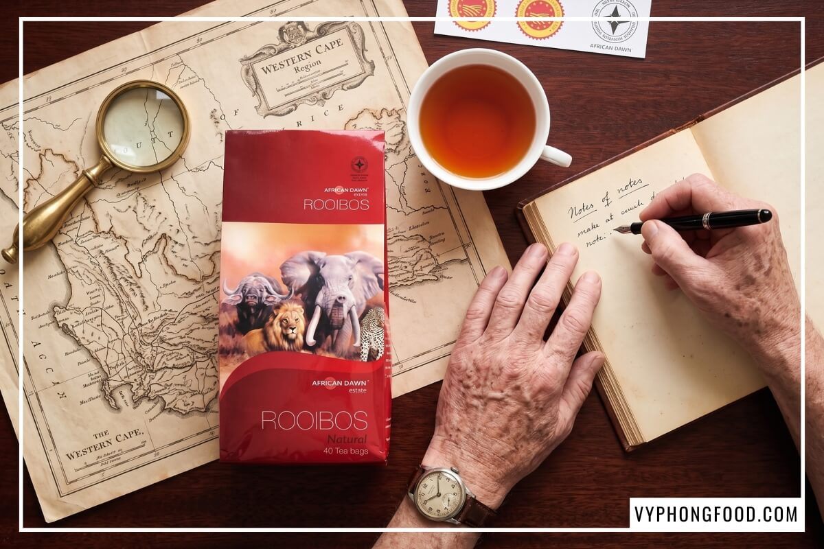 Chén thử nước trà rooibos túi lọc cho người tiểu đường cạnh bao bì và sổ ghi chép da
