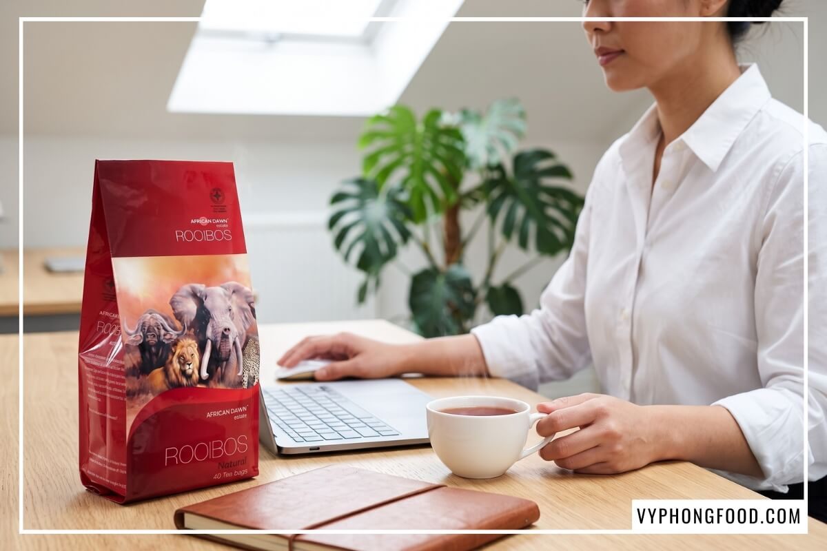 Hộp trà African Dawn 40 túi lọc trên bàn làm việc trong bài review trà rooibos túi lọc