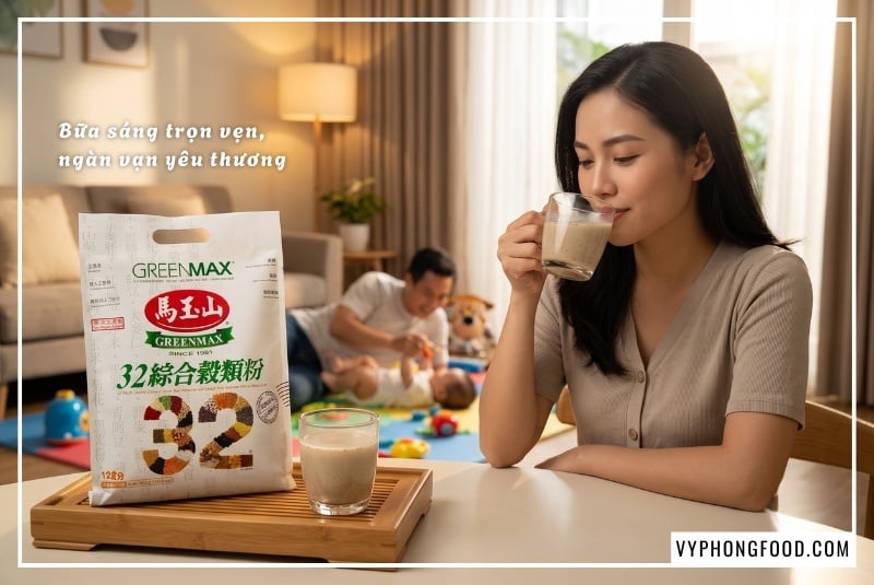 Người mẹ trẻ rạng rỡ thư thái uống ly ngũ cốc dinh dưỡng cho mẹ sau sinh Greenmax đặt trên bàn trà phòng khách, hậu cảnh là người chồng đang vui đùa cùng em bé nhỏ trên tấm thảm chơi đầy màu sắc.