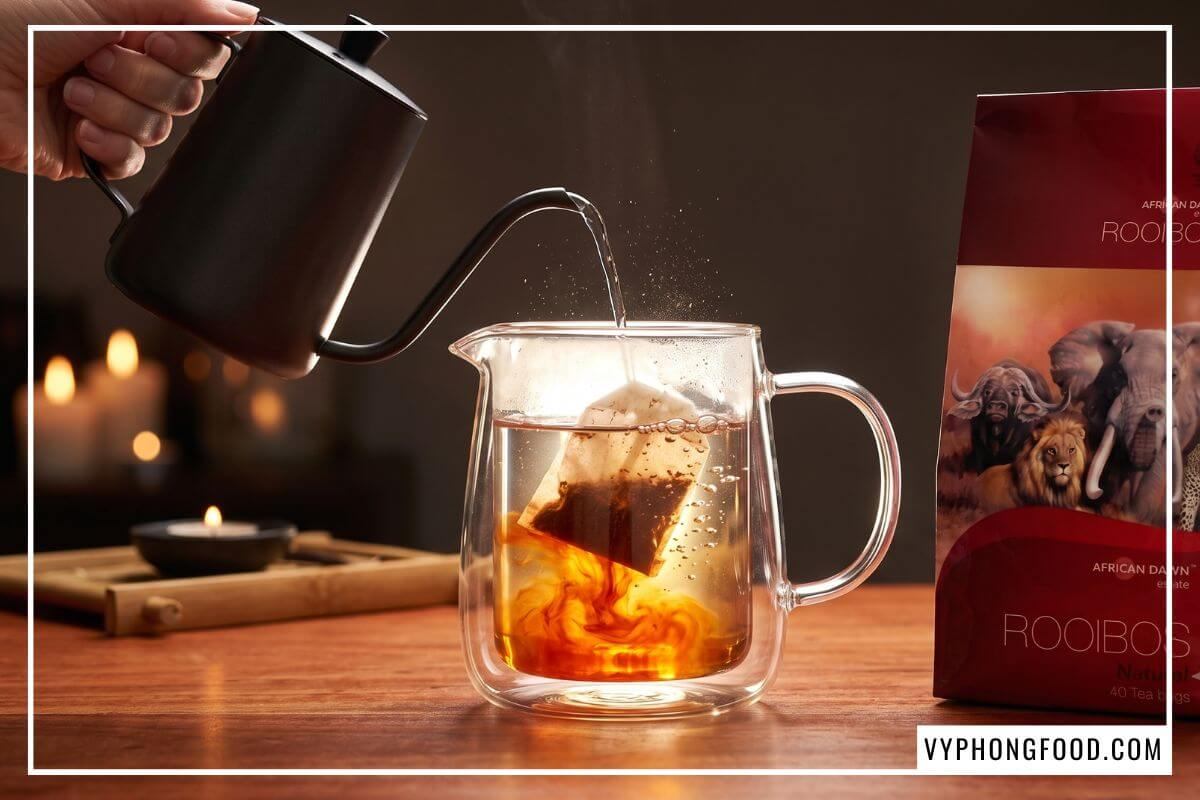 Rót nước sôi hãm bình trà không cafein tỏa sắc đỏ hổ phách bên gói trà African Dawn
