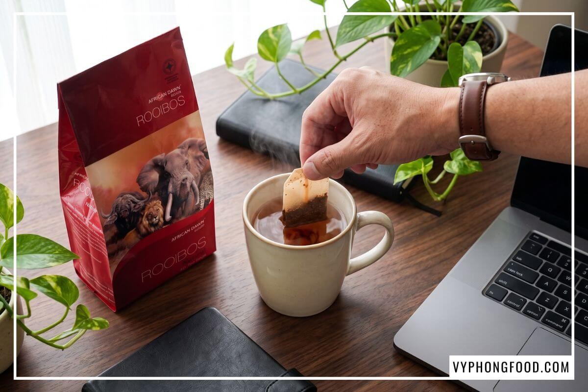 Pha trà rooibos túi lọc African Dawn trên bàn làm việc, hướng dẫn trà rooibos túi lọc mua ở đâu chính hãng tại Việt Nam.