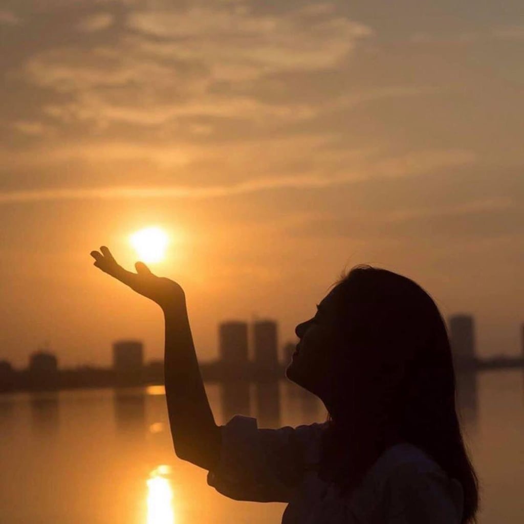 Tạo dáng chụp ảnh hoàng hôn vươn tay đón ánh nắng hoàng hôn
