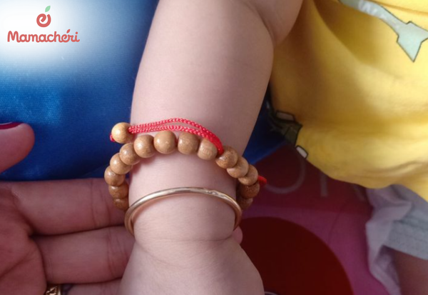Trẻ sơ sinh đeo vòng dâu tằm theo quan niệm tránh vía khi ra ngoài