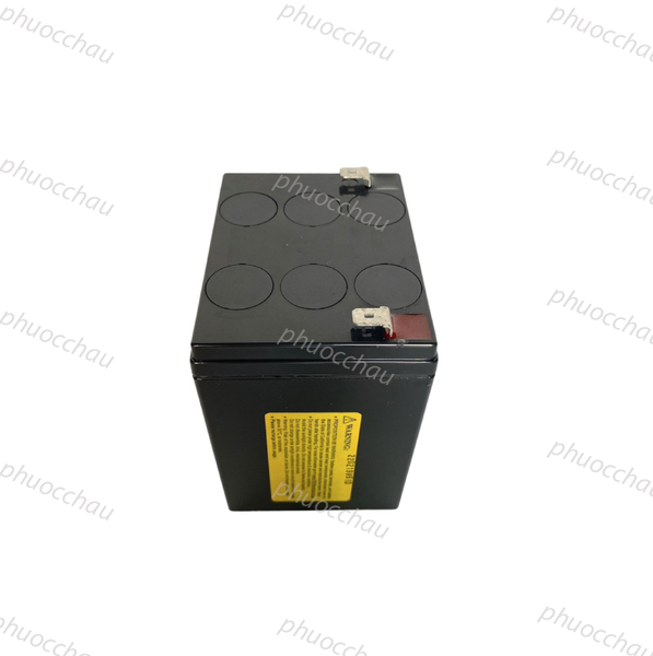 Bình ắc quy CSB HR1221WF2 12V 5Ah góc nghiêng trái, thấy mặt bên dán tem vàng cảnh báo và 2 cọc dẹt