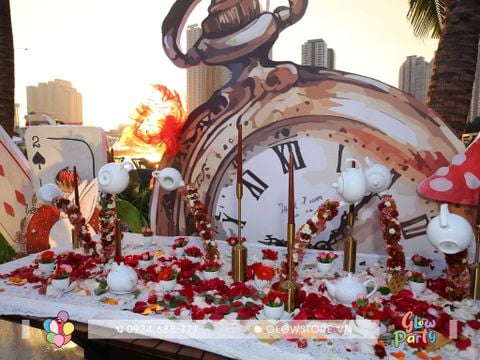 Bình trà bay lơ lửng trang trí bàn tiệc dài nghệ thuật chủ đề alice in wonderland hoa tươi màu đỏ hồng chân nến đồng mạ vàng