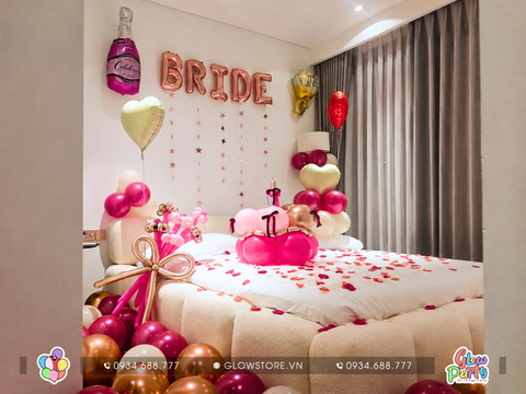 Không gian phòng cầu hôn được trang trí lãng mạn với tone màu hồng, bóng chữ Bride trên tường, giường rải cánh hoa hồng