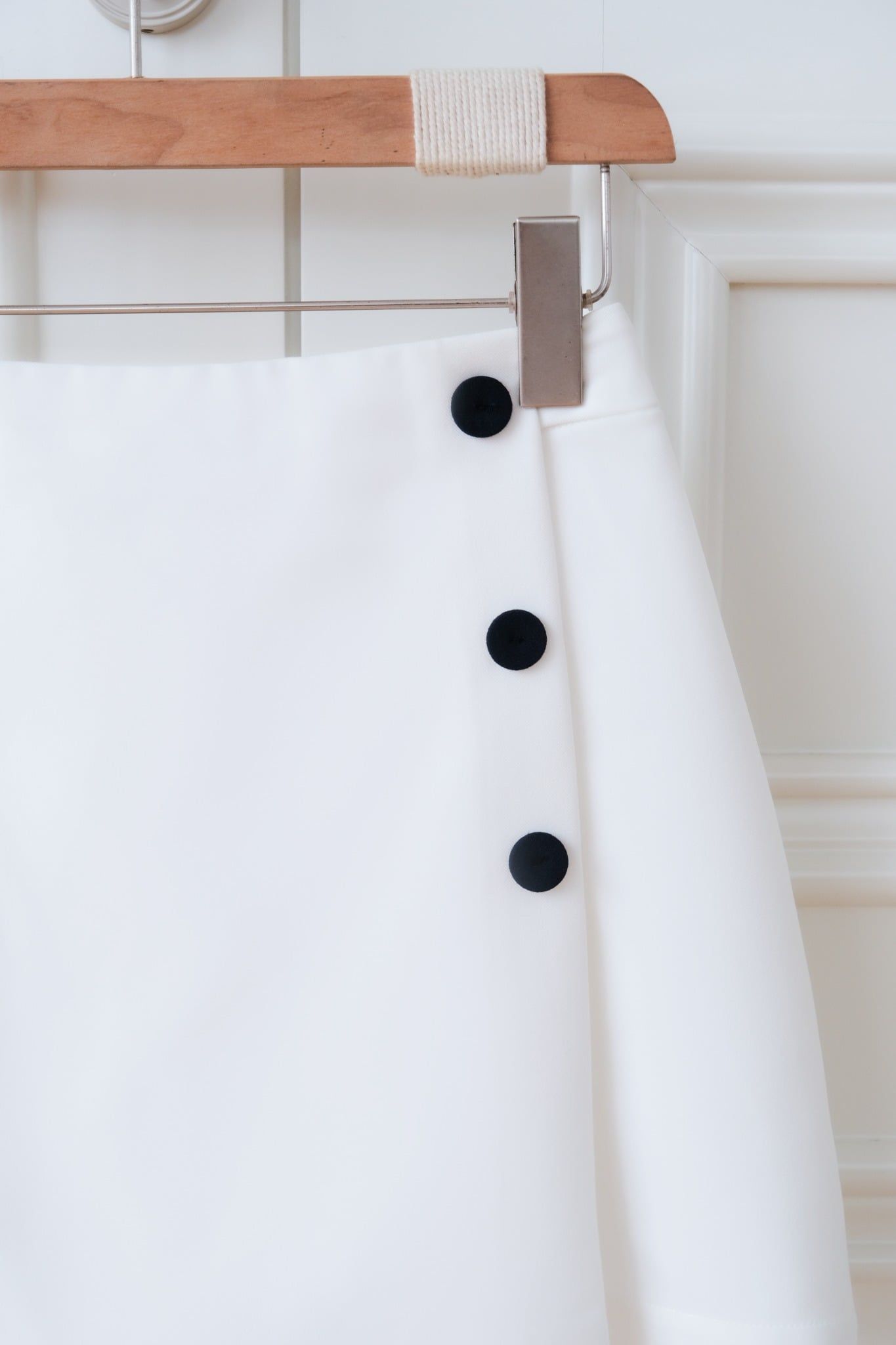 Quần chân váy trắng phối khuy trang trí