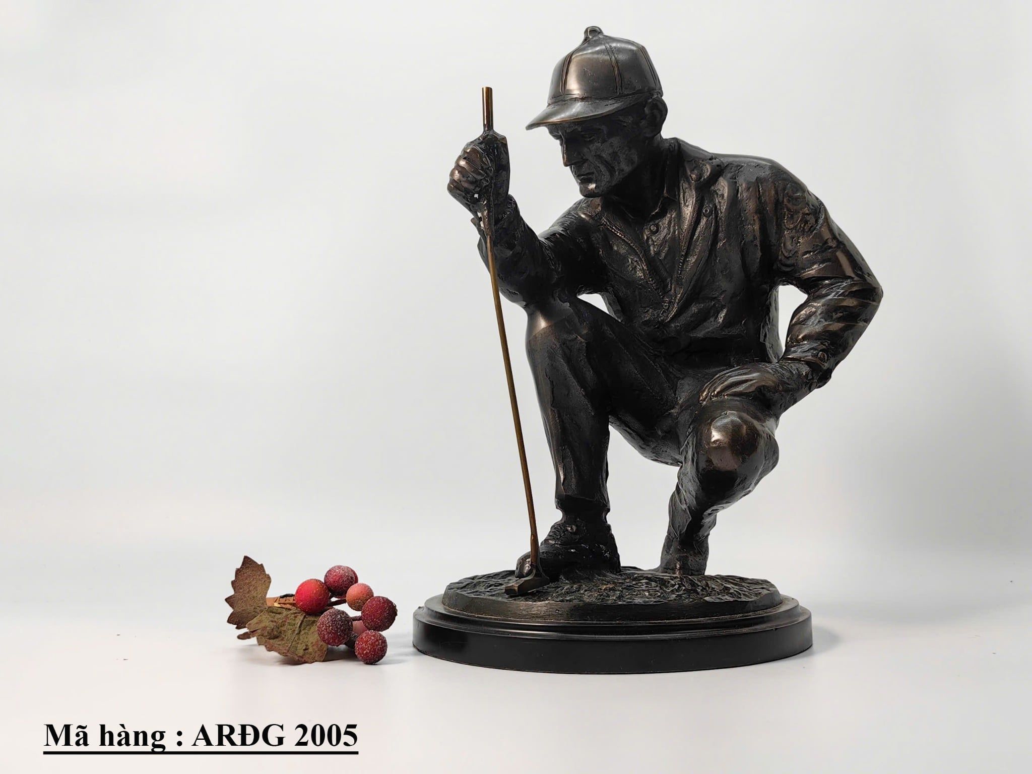 Tượng người đàn ông đánh golf đang ngồi bằng đồng.