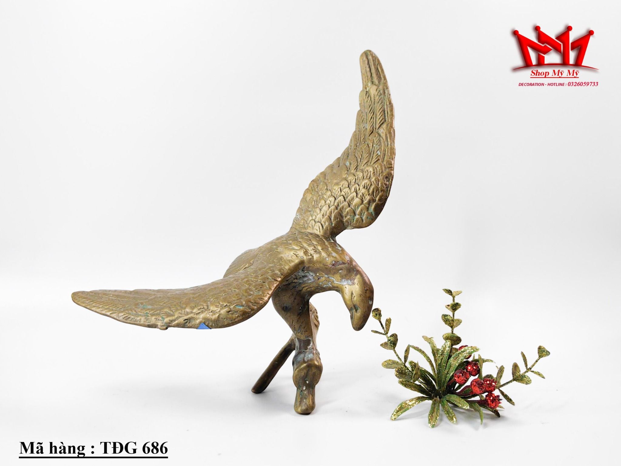 Tượng con đại bàng dang cánh đậu trên cành cây được làm bằng đồng.