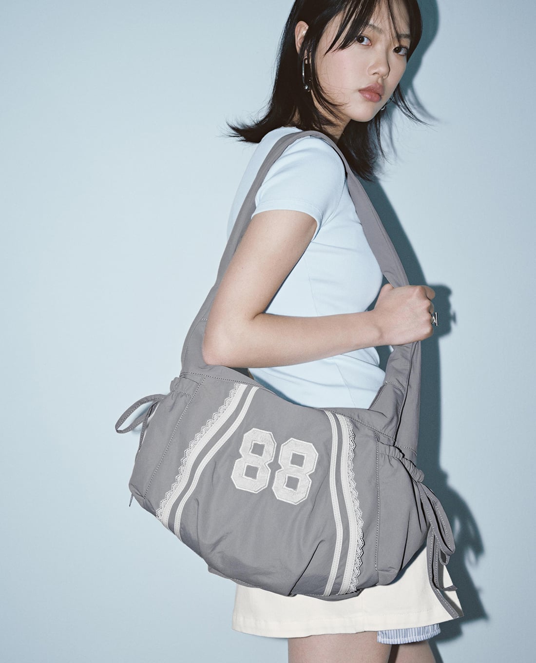 URBAN REVIVO - Túi đeo vai nữ thêu số phong cách sporty