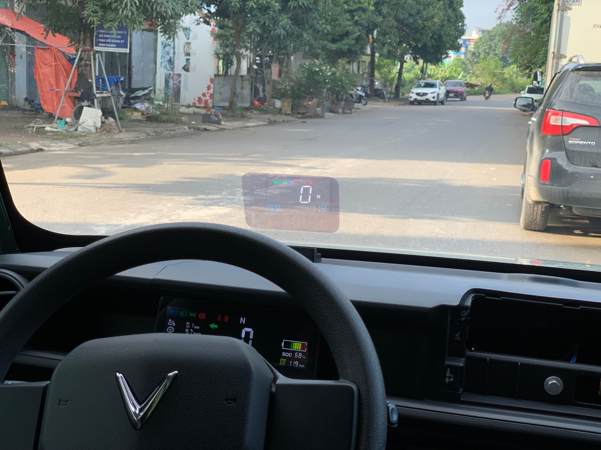 HUD MCD91 lắp trên VinFast EC Van nhìn từ ghế lái, màn hiển thị nhỏ của xe phía sau vô lăng