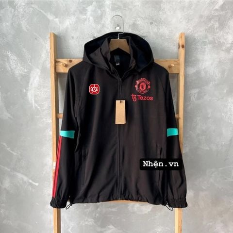 ÁO KHOÁC GIÓ MANCHESTER UNITED 2023/24 ĐEN PHỐI SỌC XANH NGỌC SỌC ĐỎ