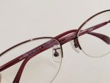  Gọng kính nữa dáng nửa viền màu đỏ tía có gắn đá lấp lánh thương hiệu Jins. 