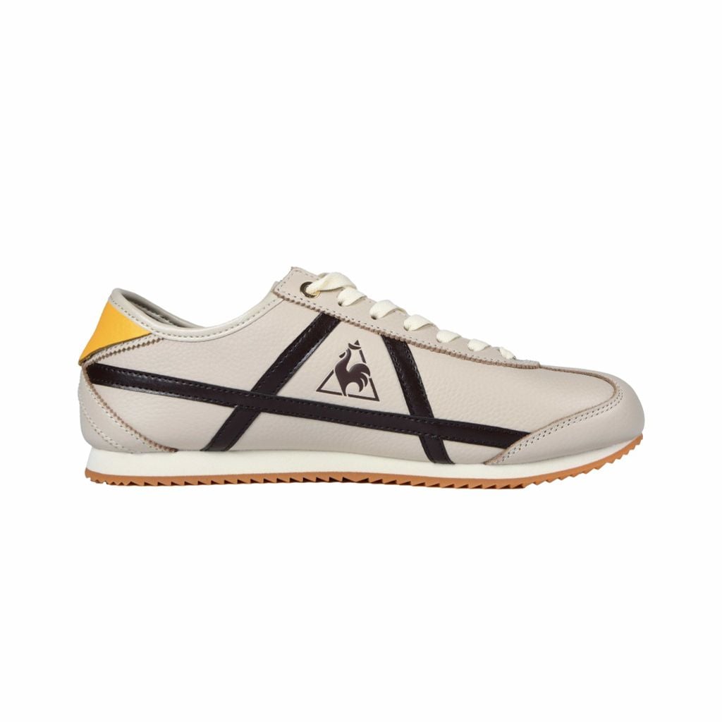 Giày Le Coq Sportif cổ điển, dải da tương phản, chi tiết vàng nổi bật ở gót.