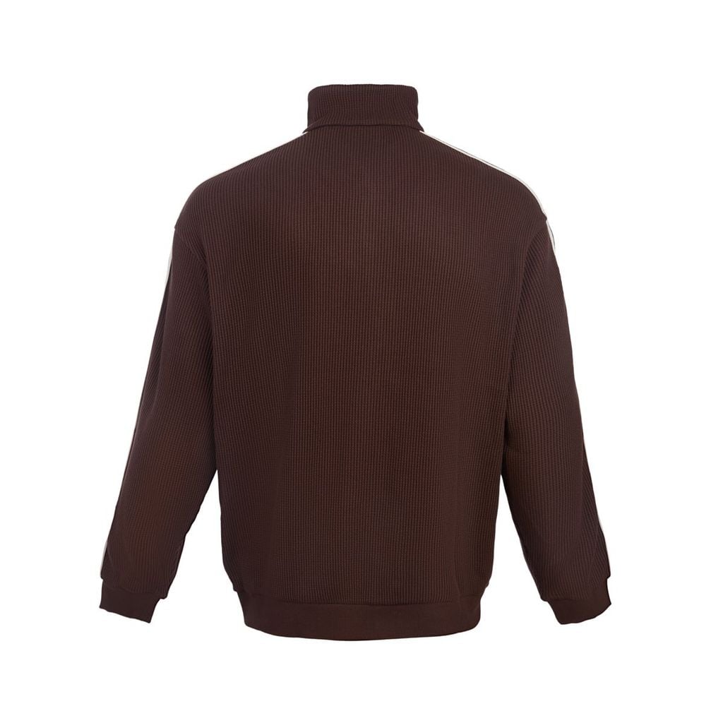 Chi tiết logo tam giác và dải vải Sunday Line trên áo cardigan Le Coq Sportif