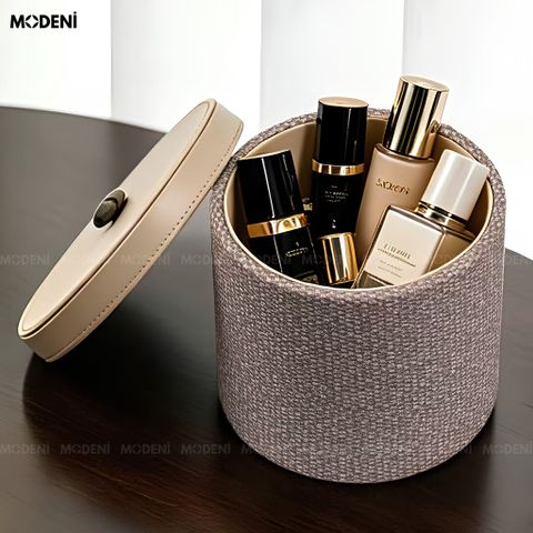Hộp đựng mỹ phẩm Liora nắp da PU màu nâu be đặt trang nhã trên quyển tạp chí cạnh ly rượu vang.
