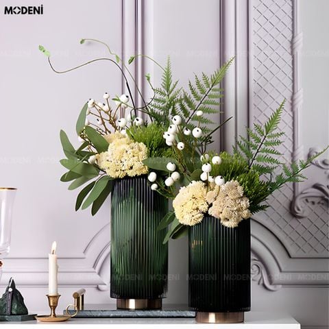 Góc nhìn chính diện hai bình hoa thủy tinh sọc gân xanh lục bảo kích thước khác nhau cắm hoa trắng đặt trên bàn đá.