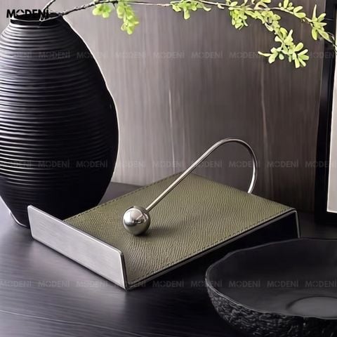 Góc chụp cận cảnh từ trên xuống nắp hộp khăn giấy Vega bằng thép không gỉ mài xước, tạo cảm giác sang trọng và chắc chắn.