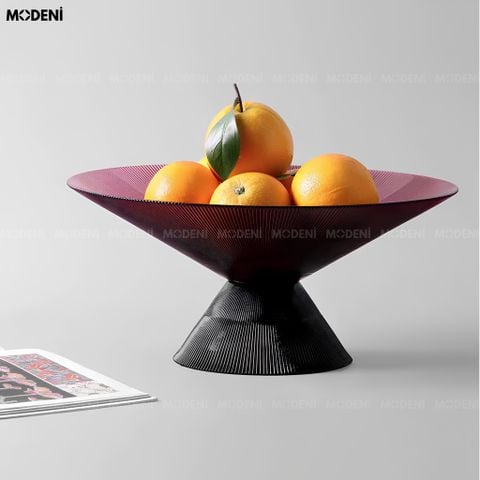 Góc chụp ngang tô trái cây thủy tinh sọc gân màu tím thạch anh đế kim loại đen đựng cam vàng.