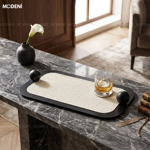 Bối cảnh bàn đá cẩm thạch xám trưng bày khay trang trí viền đen phối cùng ly rượu và bình hoa sang trọng.