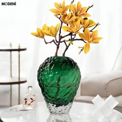 Góc nhìn chính diện bình hoa thủy tinh sần Vulcan xanh lục bảo cắm hoa mộc lan vàng trên bàn trà.