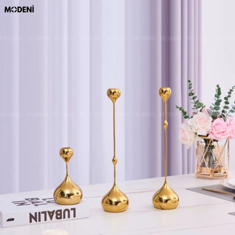 Góc chụp nghiêng trên bàn đá marble bộ chân nến decor sang trọng Yusla màu vàng gold phản chiếu ánh sáng đặt cạnh.