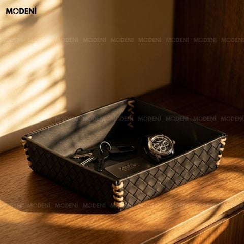 Góc chụp trên bàn trang điểm khay trang trí vuông bọc da đen đựng chuỗi ngọc trai, đồng hồ và nhẫn lấp lánh cạnh nến thơm.