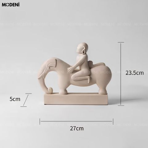 Góc nhìn chính diện tượng trang trí Nomad composite trừu tượng màu be đặt trên chồng sách nghệ thuật.