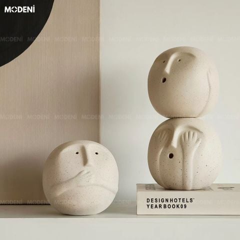 Góc chụp ngang trên kệ trắng, bộ ba tượng trang trí màu be Silento Viso Auri nổi bật với tạo hình khuôn mặt tròn tối giản.