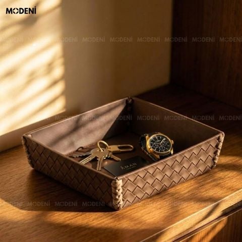 Góc chụp dưới nắng trên bàn gỗ tròn khay trang trí nội thất phòng khách bọc da nâu đậm đựng nến thơm và thanh gỗ palo santo.