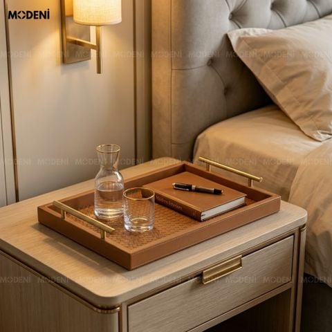 Góc chụp nghiêng trên bàn tròn đen khay trang trí bàn trà bọc da nâu đựng nước hoa kính và chuỗi ngọc trai.
