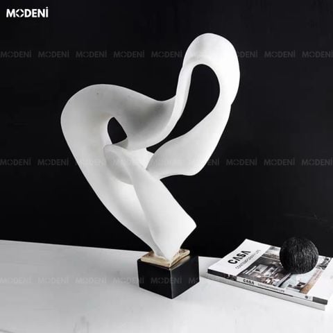 Bối cảnh tủ console đen sang trọng, tượng trang trí Oldel White nổi bật với đường dải lụa lượn sóng màu trắng bồng bềnh.