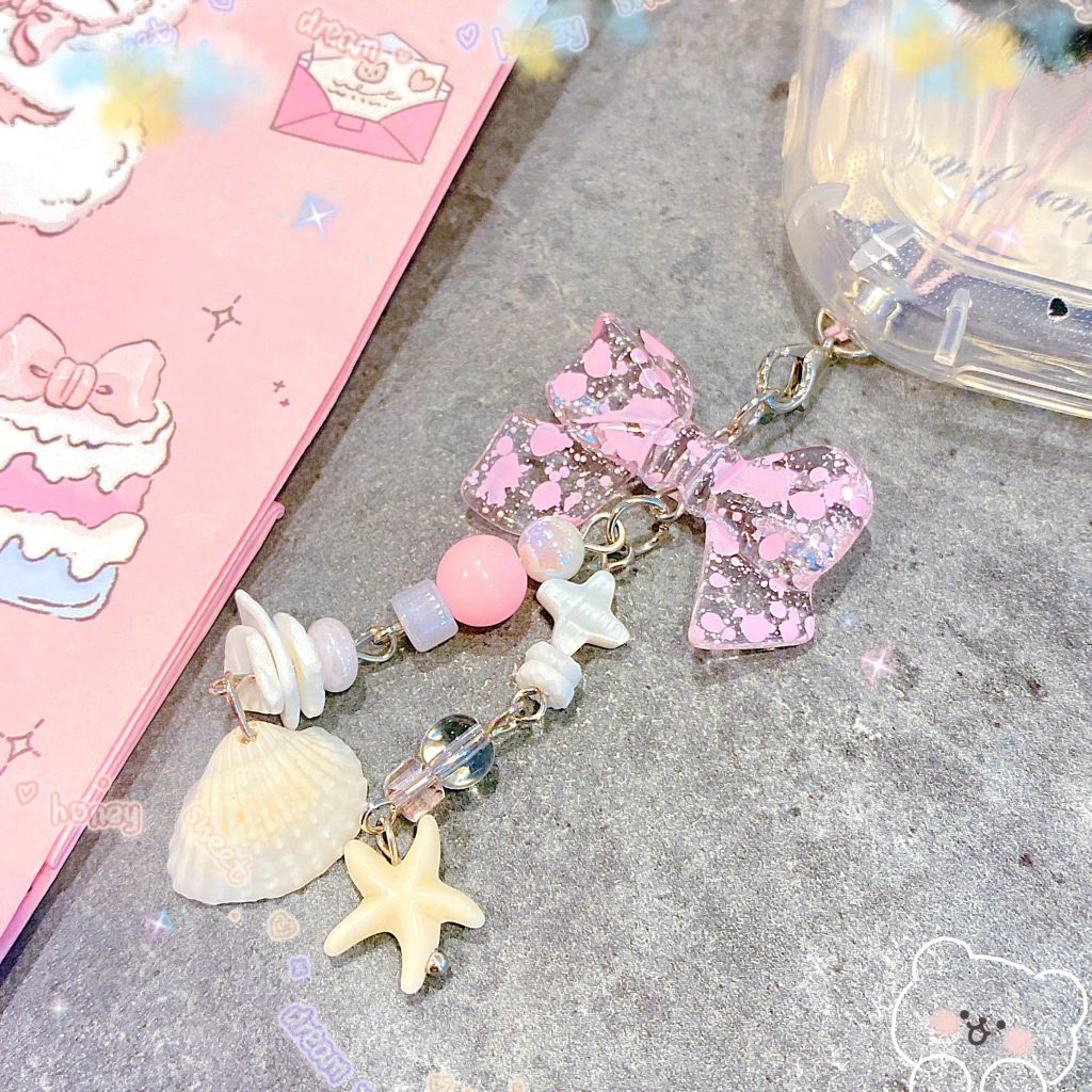 ** Móc khóa nơ hồng vò sò