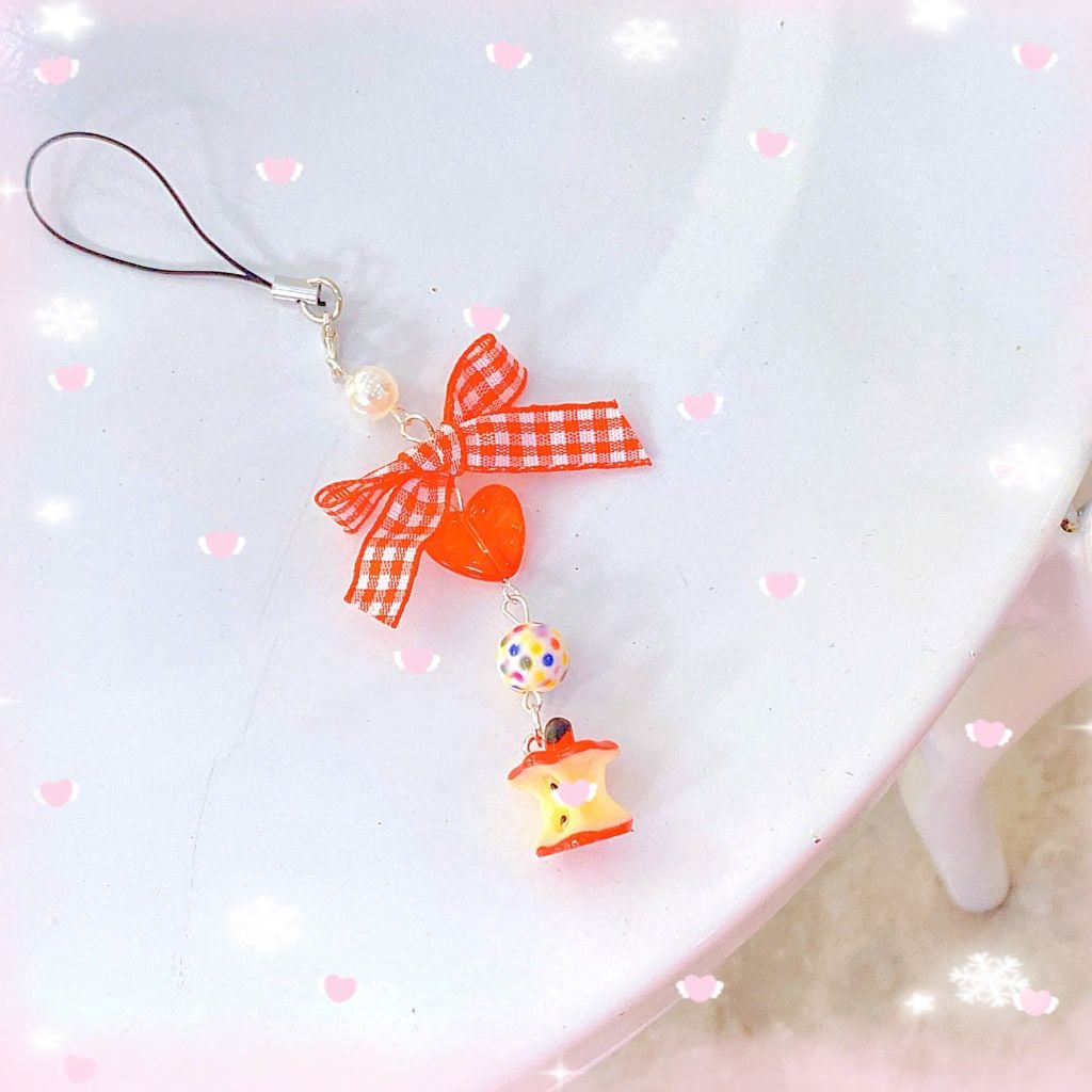 ** Dây đeo điện thoại quả táo cắn dở kèm nơ