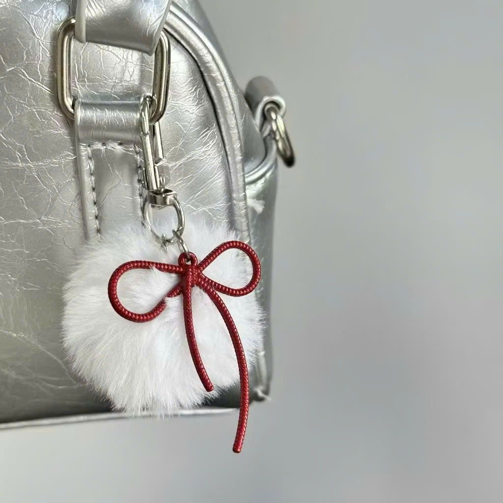 ** Móc khóa lông trắng nơ bạc và đỏ