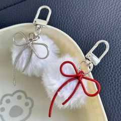 ** Móc khóa lông trắng nơ bạc và đỏ