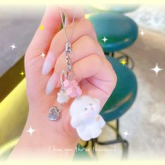 ** Dây đeo điện thoại cún trắng phủ lông nơ hồng