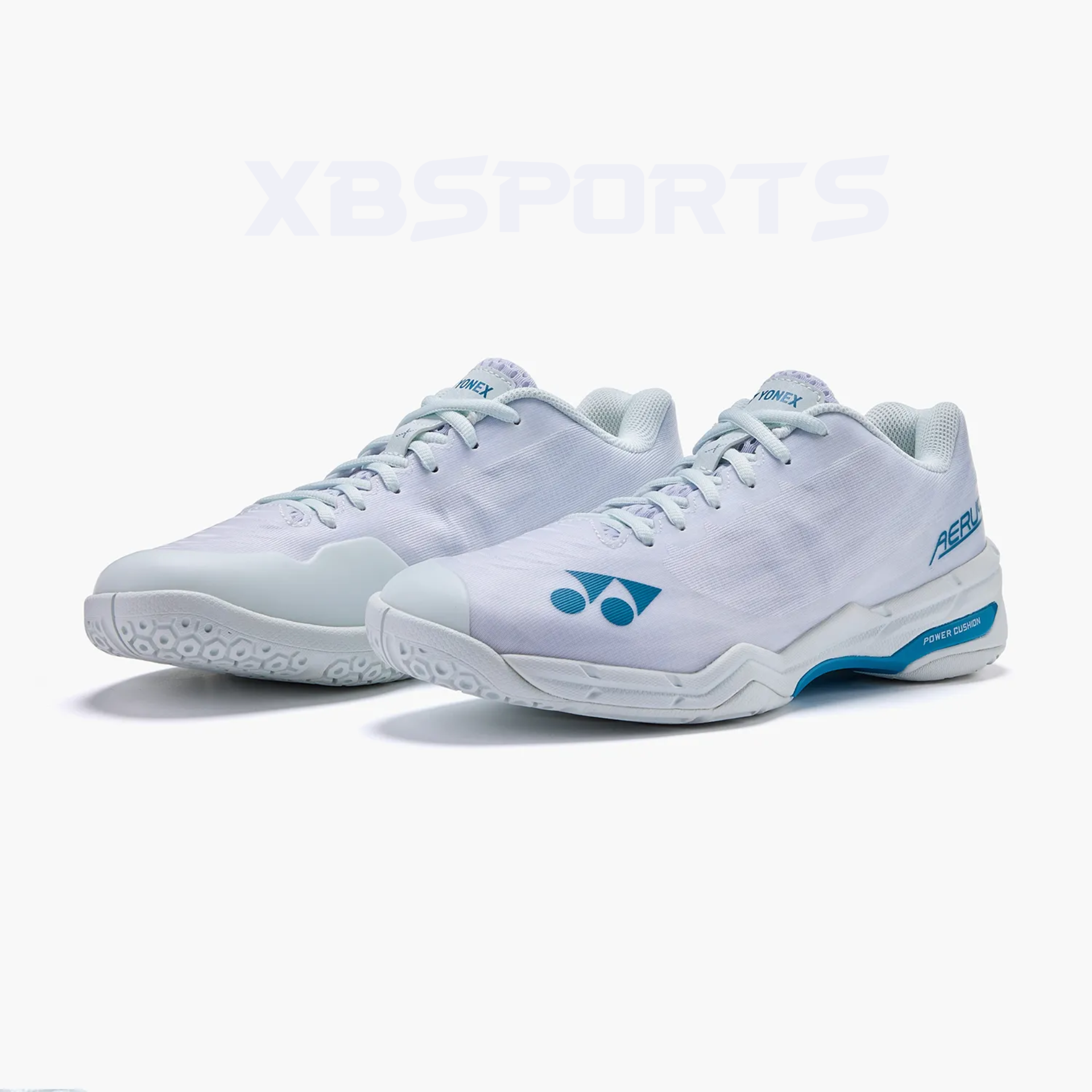 Đôi giày cầu lông màu trắng nhìn chếch từ phía trước, thân giày lưới dệt mịn, logo Yonex và chữ AERUS màu xanh dương ở má ngoài, đế giữa trắng